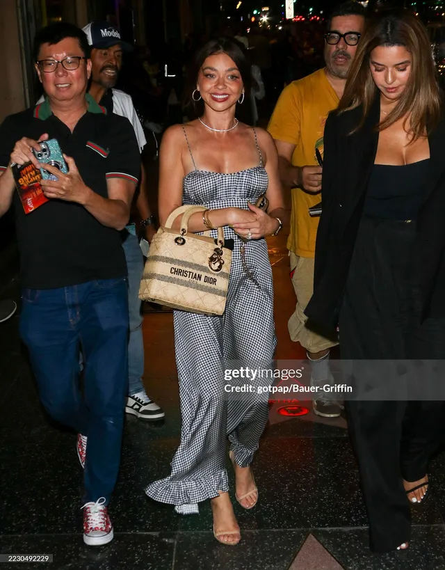 Sarah Hyland walking with companions in a grey dress.