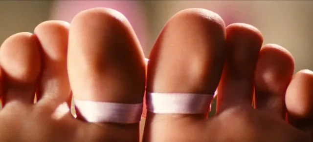 Sydney Sweeney: close view of toes decorated with pink bows.
