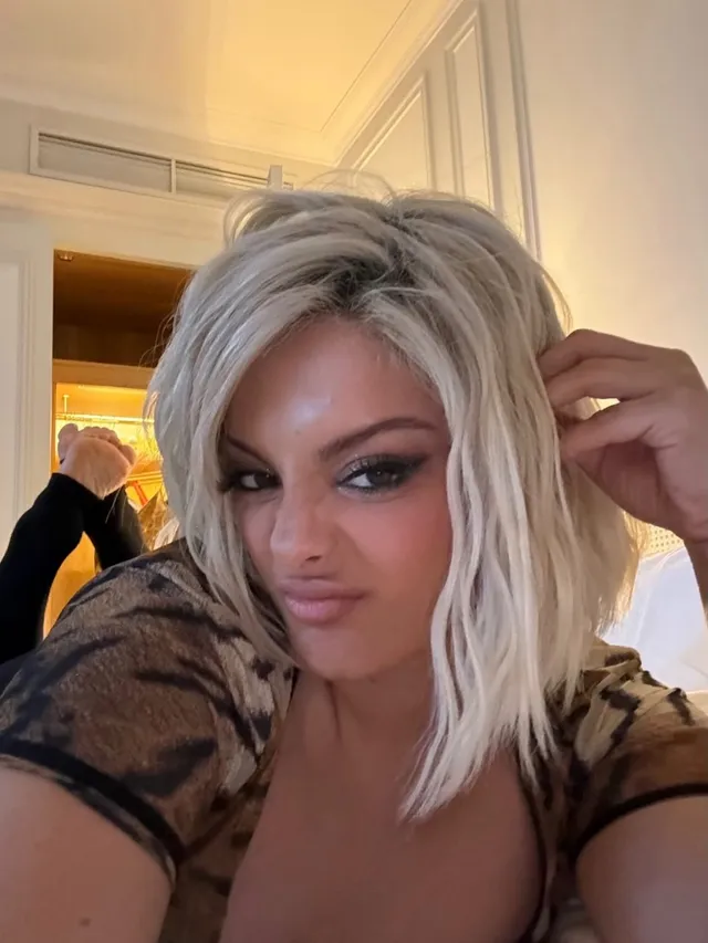 Bebe Rexha taking a close-up selfie with blonde hair.