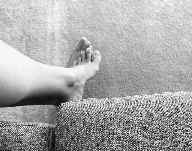 Yvonne Strahovski resting a bare foot on a sofa for a black-and-white photograph.
