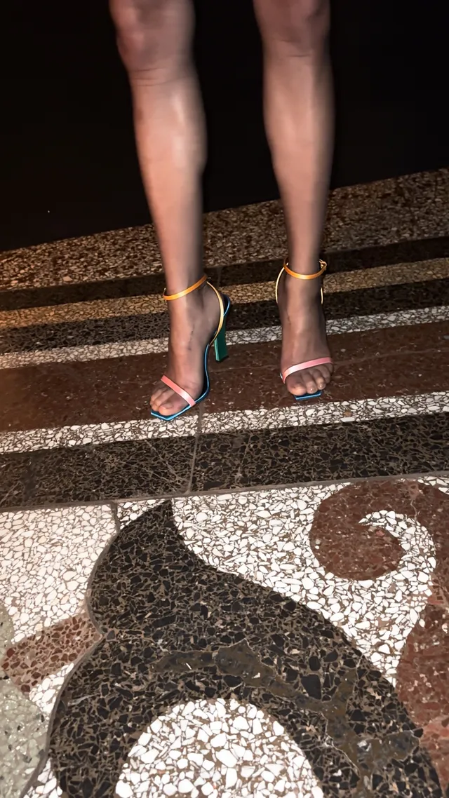 Zoë Kravitz wearing multicoloured sandals on stone steps.