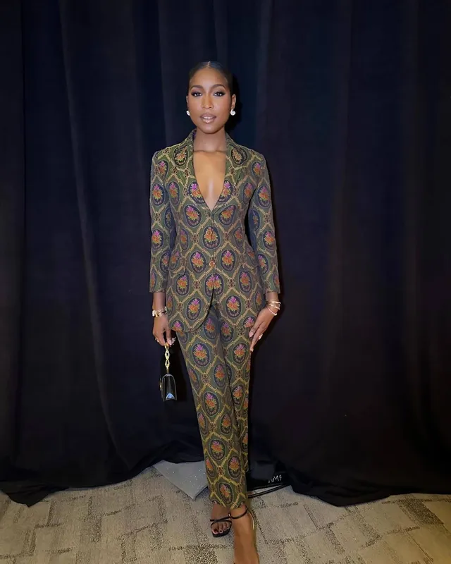 Carlacia Grant wearing a patterned fitted dress and strappy heels at an event.