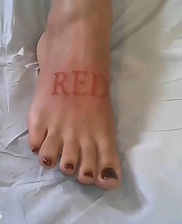 Doja Cat showing a bare foot with red lettering.