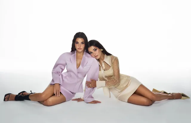 Hande Erçel posing with a friend in black heeled sandals.