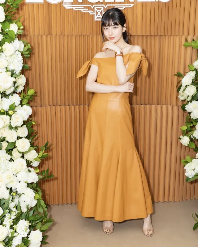 Bae Suzy wearing a yellow dress and pale heels.