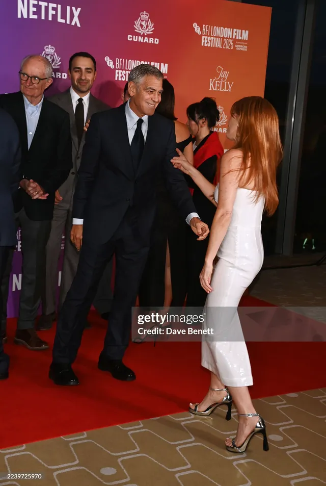 Isla Fisher posing with cast members at a film premiere.