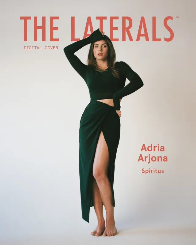 Adria Arjona posing barefoot in a green outfit for a magazine cover.