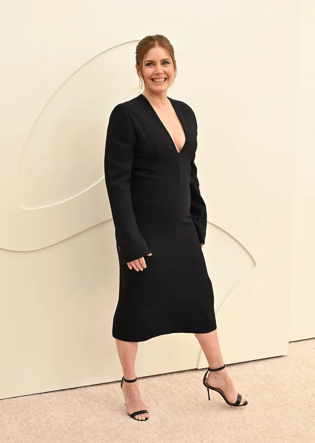 Amy Adams posing at an event in a black dress.