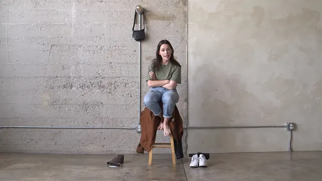 Victoria Pedretti sitting on a stool during a portrait shoot.