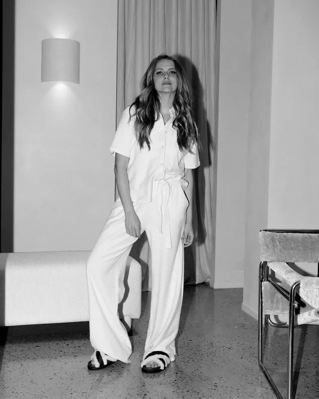 Teresa Palmer standing for a black-and-white portrait in a white outfit.
