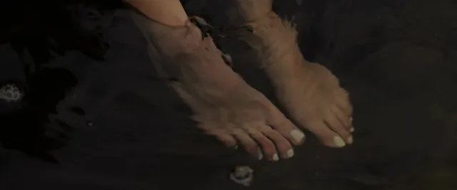 Anna Kendrick showing bare feet on woodland ground.