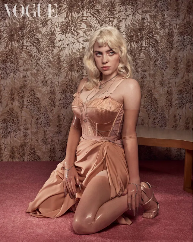 Billie Eilish a kneeling fashion portrait in sheer tights and heels.