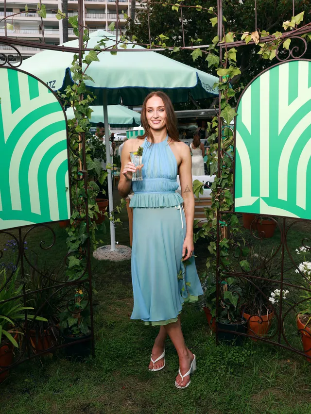 Sophie Turner a blue summer dress at a garden event.