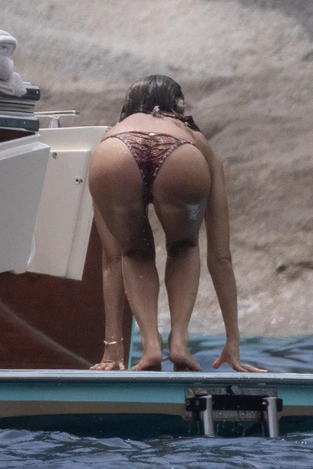 Jessica Alba leaning forward barefoot on a paddleboard.