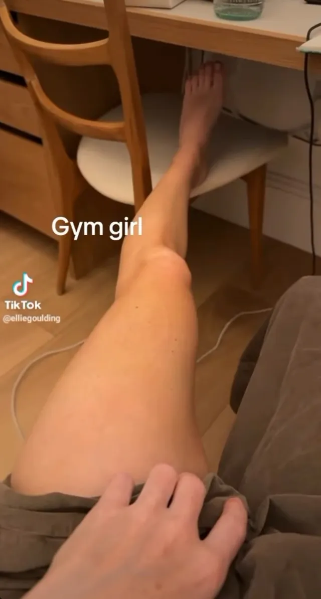 Ellie Goulding resting crossed bare legs beside a chair.