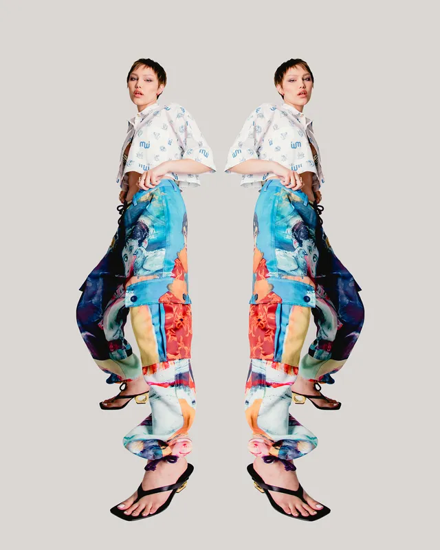 Grace VanderWaal posing in colorful trousers and flat sandals.