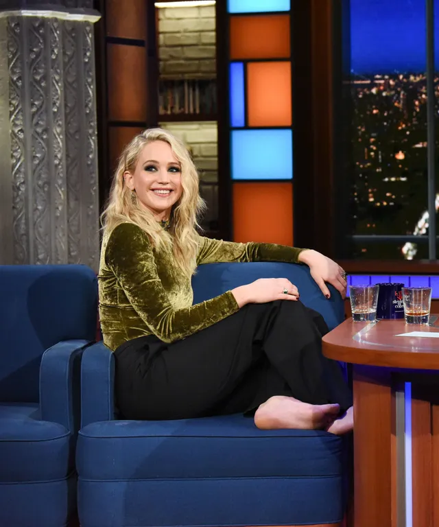 Jennifer Lawrence sitting barefoot during a television interview.