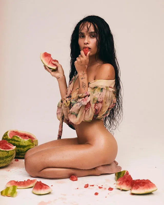 Zoë Kravitz sitting beside sliced watermelon in a studio portrait.