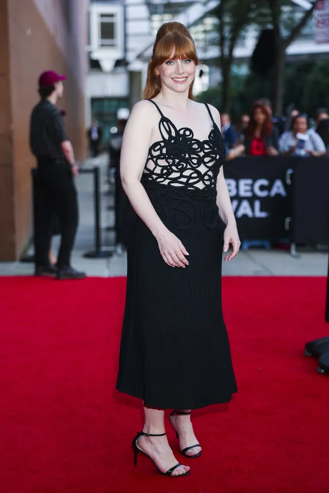 Bryce Dallas Howard posing on a red carpet in a long black dress.