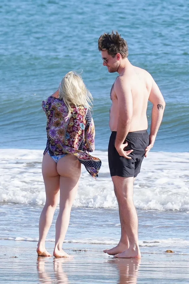 Ariel Winter walking beside a companion in shallow water.