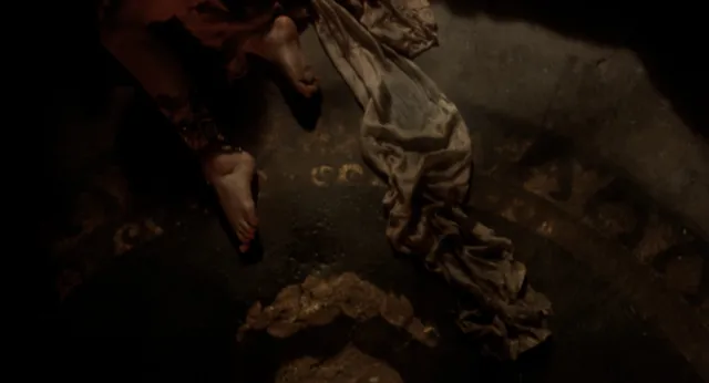 Monica Bellucci a dimly lit reclining screen scene.
