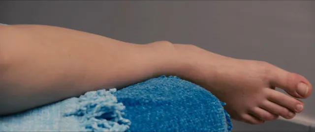 Adèle Exarchopoulos resting a bare foot on blue fabric.