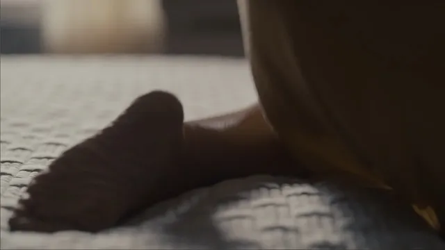 Elizabeth Olsen resting with a bare foot visible on a bed.