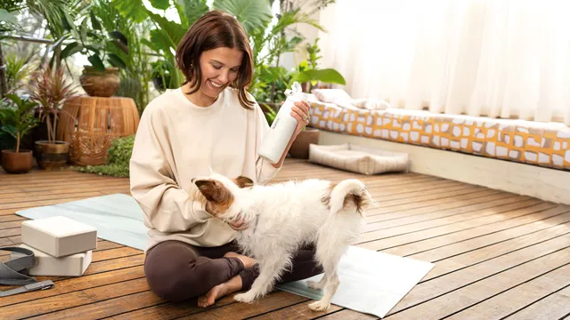 Millie Bobby Brown sitting beside a dog on a terrace.