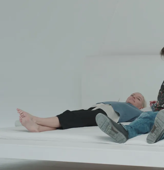 Kate Bosworth lying on a bed in a bright screen scene.