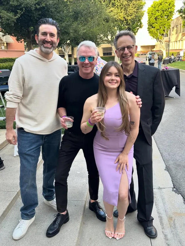 Ariel Winter posing with companions outdoors in a lilac dress.