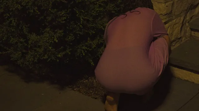 Odessa A'zion crouching barefoot outside at night in a scene.