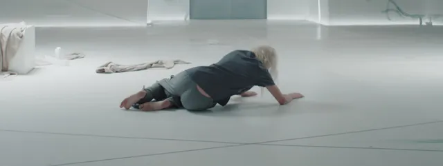 Kate Bosworth moving across a pale floor in a screen scene.