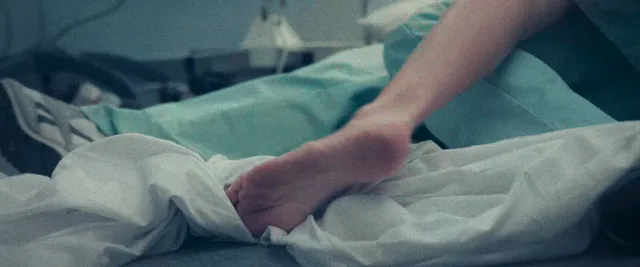 Catherine Zeta-Jones lying on a bed with bare feet visible.