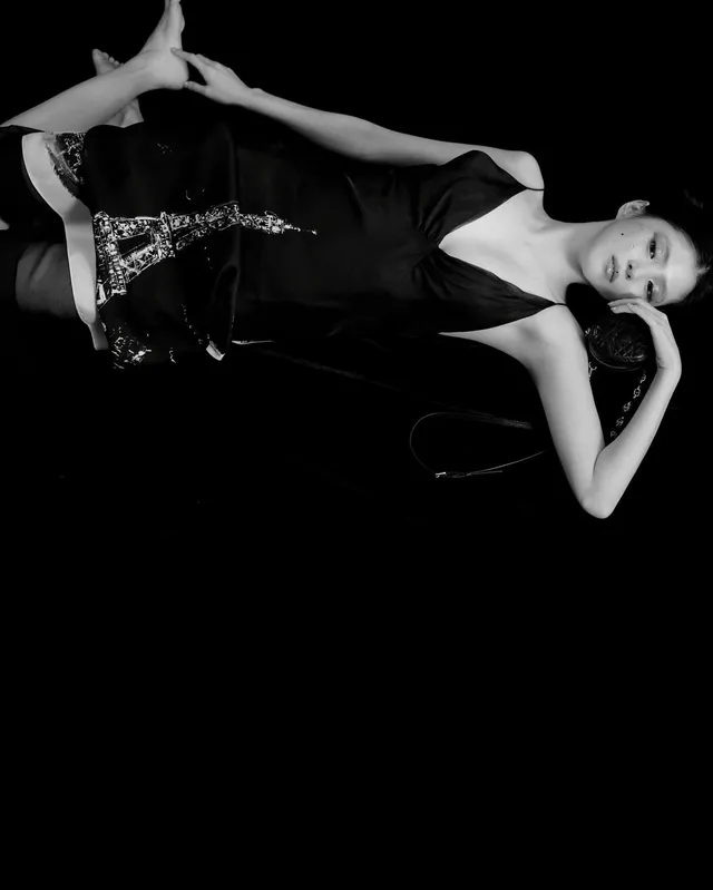 Han So-hee reclining in a black outfit in a monochrome photograph.
