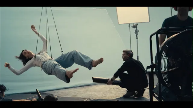 Cara Delevingne appearing suspended during a studio screen shoot.