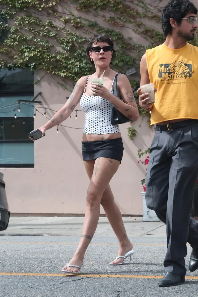 Halsey a casual white top and flip-flops on a street.