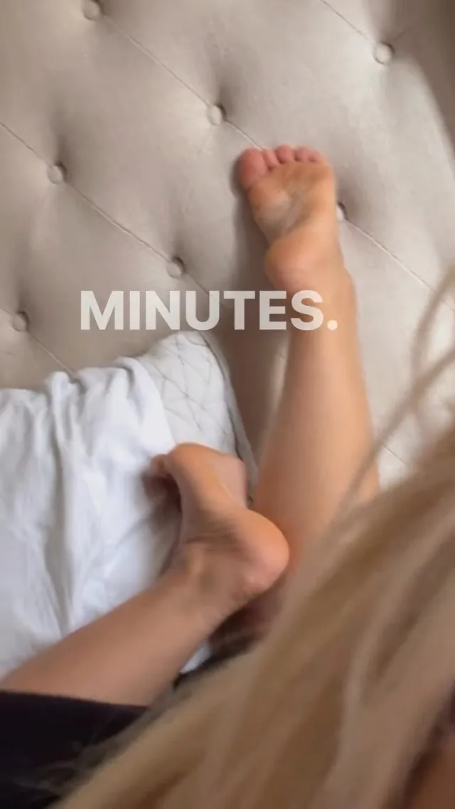 Bebe Rexha resting a bare foot against a tufted headboard.