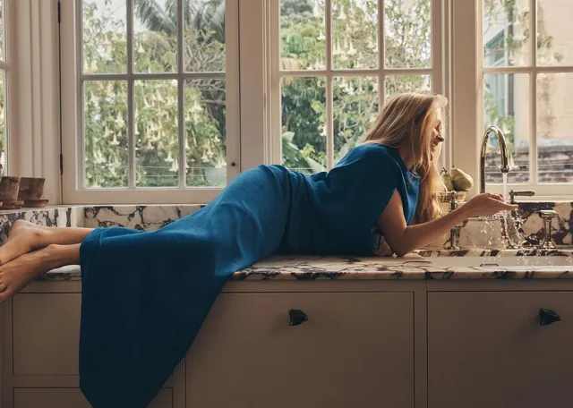 Teresa Palmer lying beside a window during a portrait shoot.