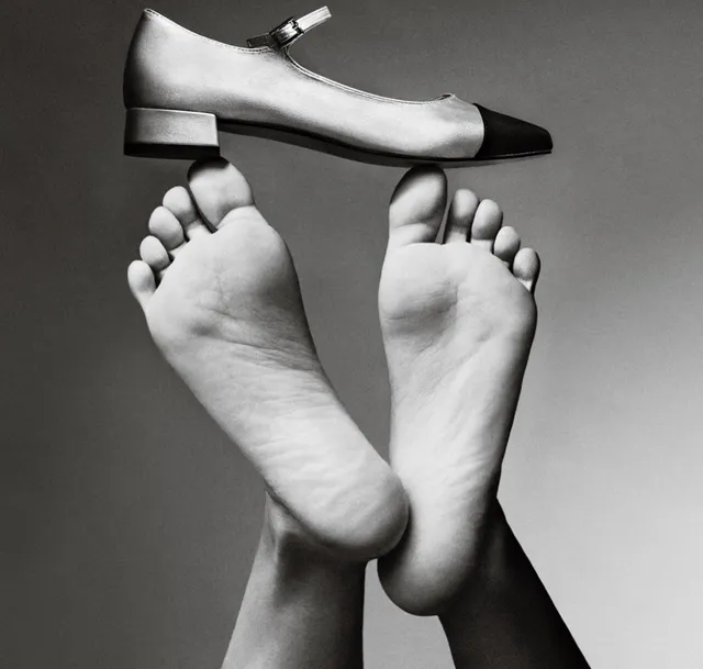 María Pedraza shown in a monochrome close-up of bare feet beside a two-tone shoe.