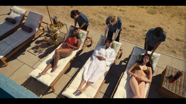 Sophie Wilde relaxing barefoot on a sun lounger among other people.