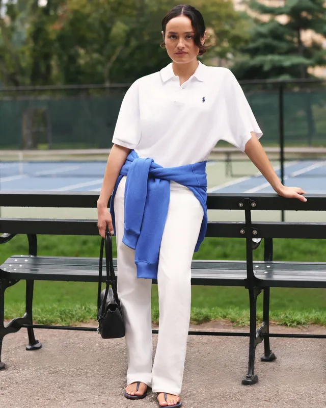 Chase Sui Wonders standing beside a table in white trousers and flat sandals.