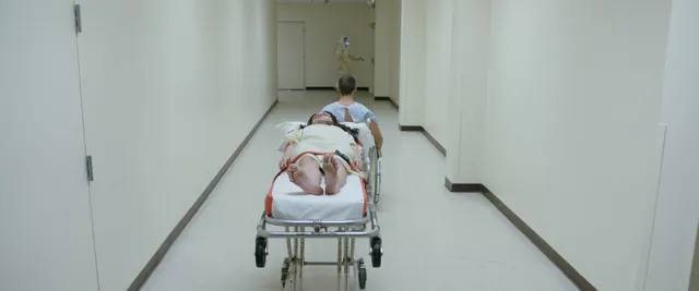 Olivia Cooke lying on a hospital trolley in a screen scene.
