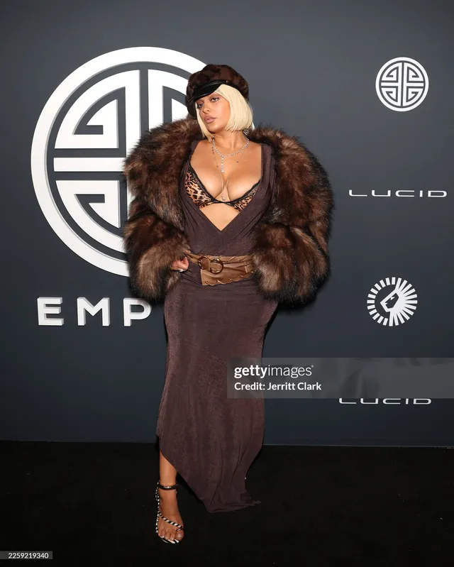 Bebe Rexha posing in a brown outfit and platform heels.
