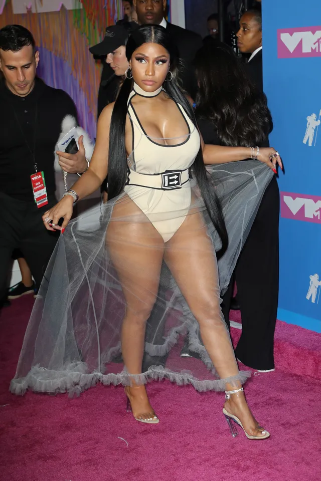 Nicki Minaj posing at an awards event in metallic heels.