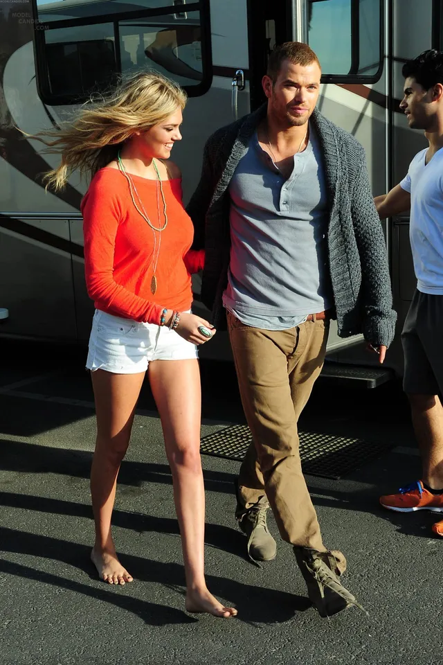 Kate Upton walking barefoot beside another person in a screen image.
