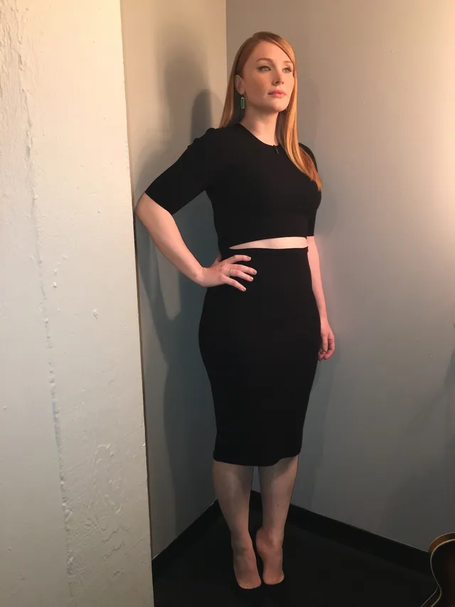 Bryce Dallas Howard posing indoors in a short black outfit.