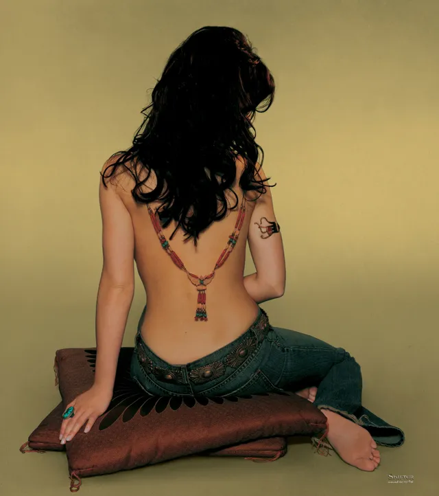 Jennifer Love Hewitt sitting on a cushion with a bare sole visible in a studio portrait.