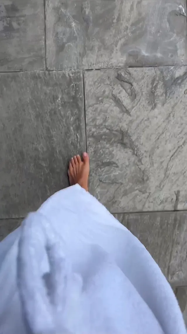 Kiana Madeira shown with a bare foot visible beneath a white robe.