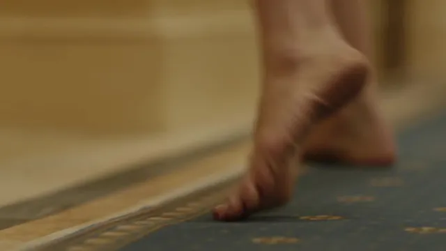 Olivia Wilde raising a bare heel in a film scene.
