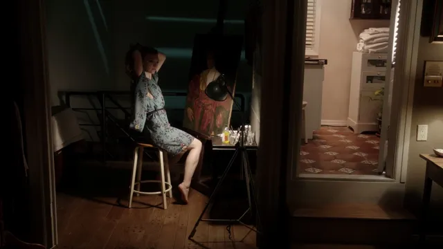 Natalie Dormer sitting at a table during a fashion shoot.